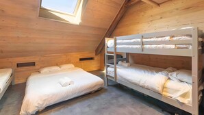 Un dormitorio con literas, tragaluz y paredes de madera.