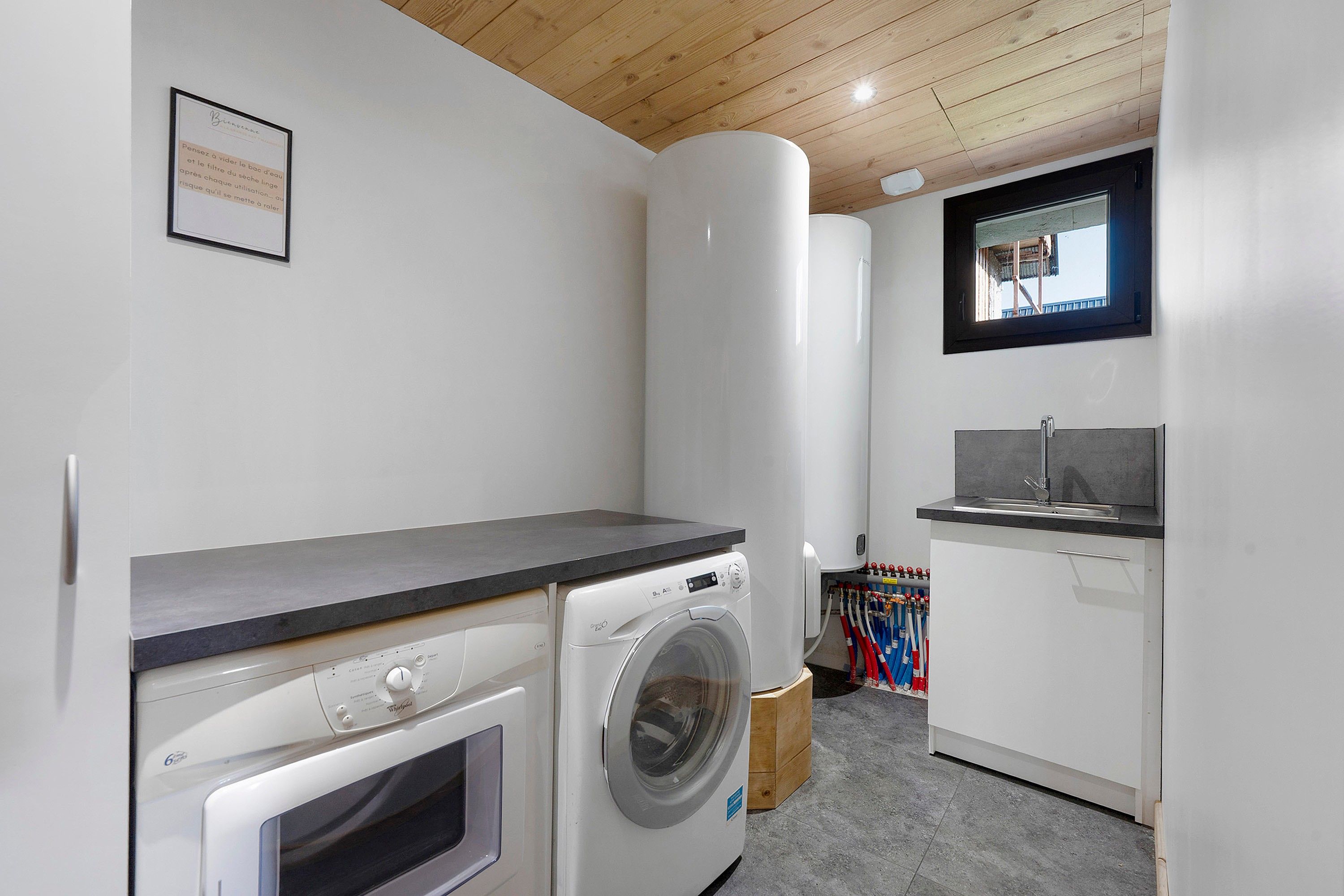 A laundry room with a washing machine, dryer, and a sink.