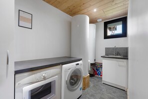 A laundry room with a washing machine, dryer, and a sink.