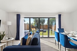 Ein modernes Wohnzimmer mit einer Couch, einem Esstisch und Stühlen.