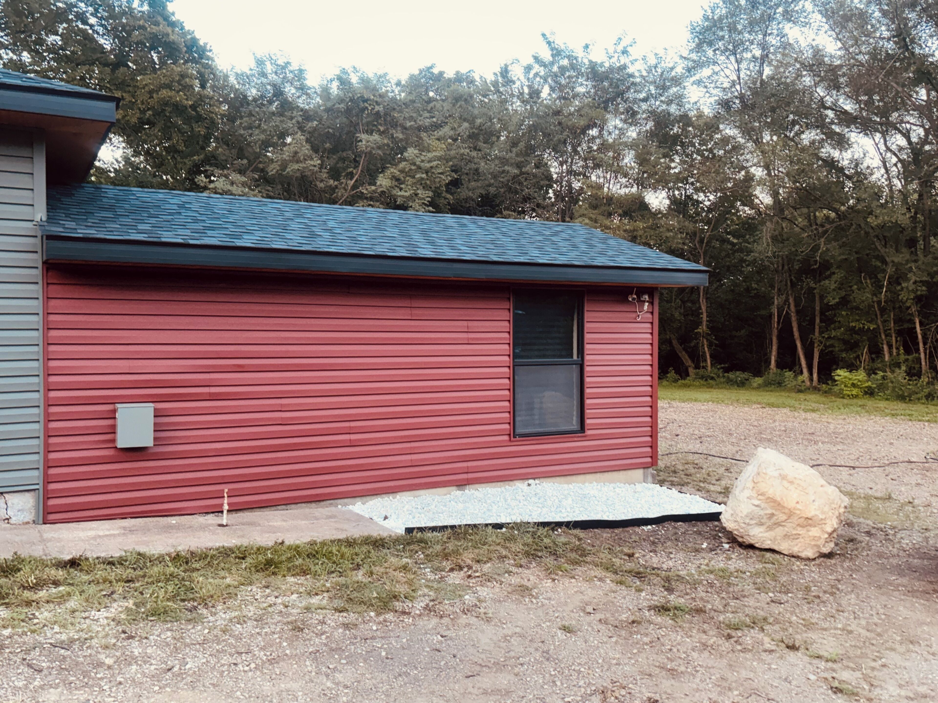A small, single-story building with a red exterior and a dark roof.