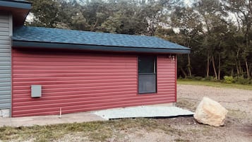 Un petit bâtiment d’un seul étage, à la façade rouge et au toit foncé.