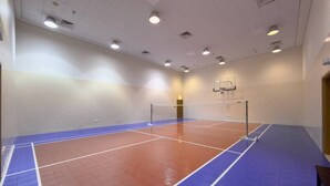 Eine Sporthalle mit Basketballfeld, Volleyballnetz und Basketballkorb.