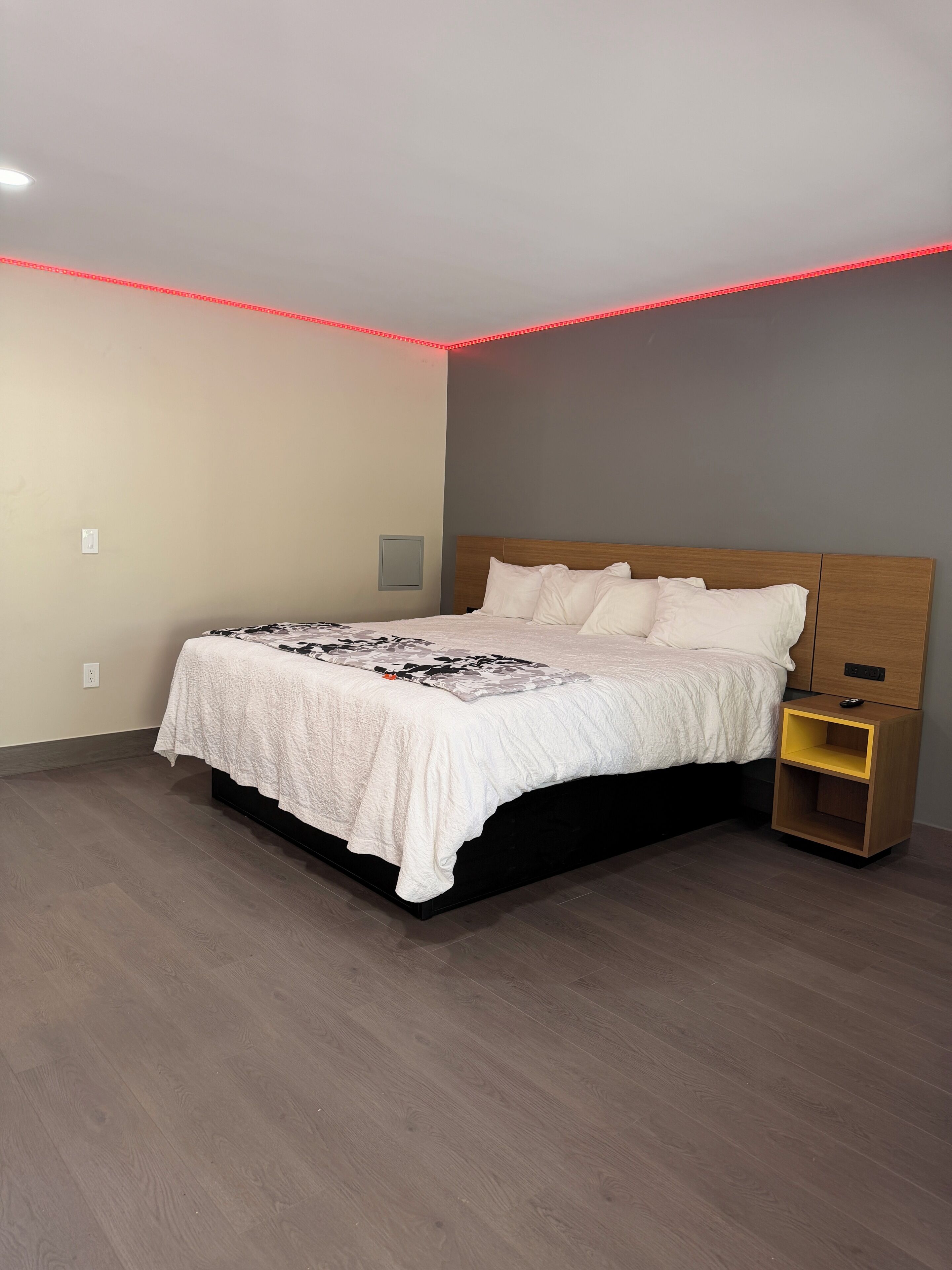 Una camera da letto con un letto, un comodino e una lampada a muro.