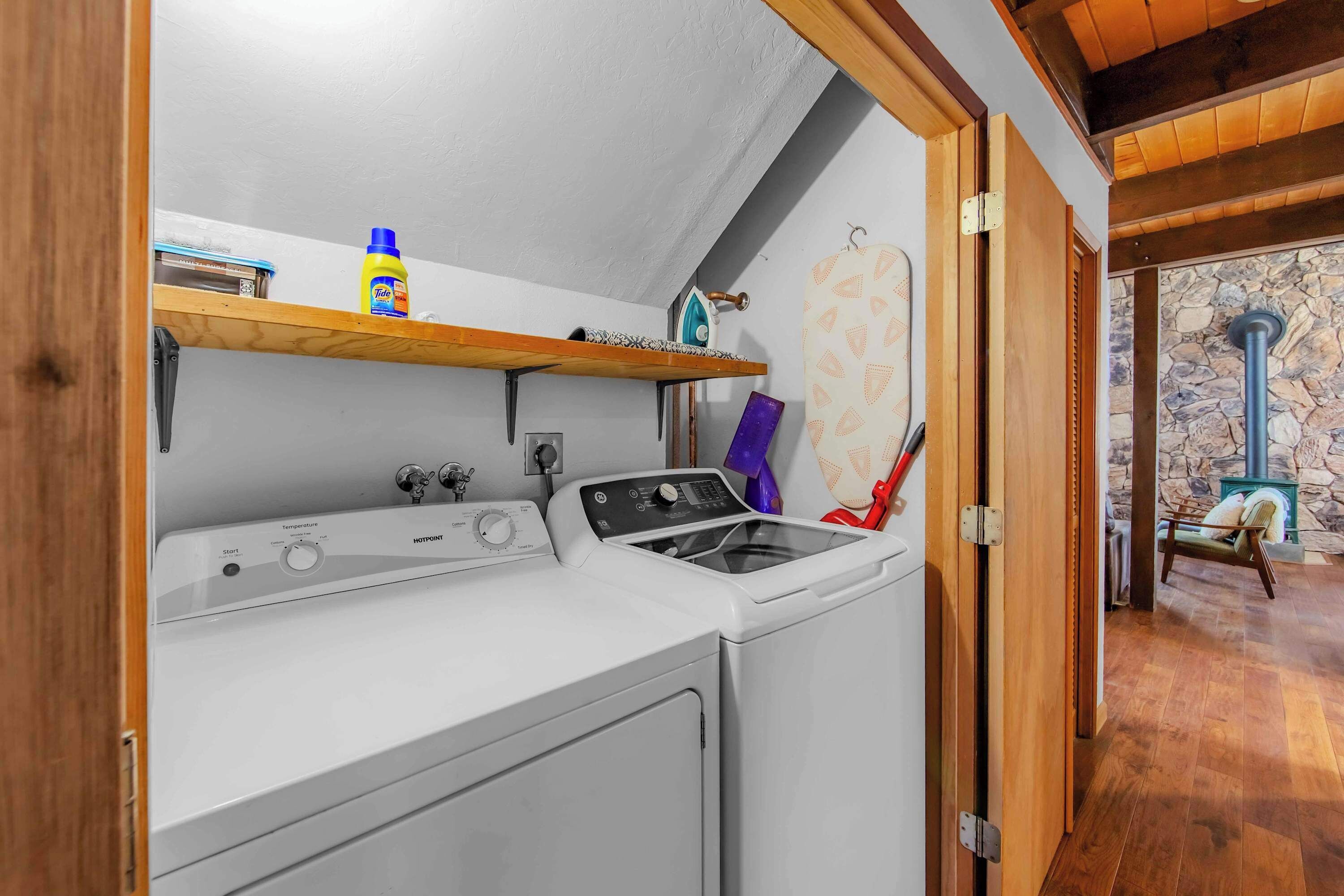 A laundry area with a washing machine, an iron, and a drying rack.