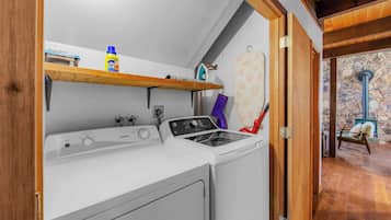 A laundry area with a washing machine, an iron, and a drying rack.