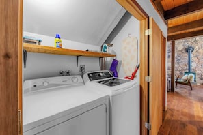 A laundry area with a washing machine, an iron, and a drying rack.