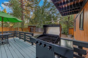 An outdoor barbecue grill with a wooden deck and a green umbrella. - Lakewood Escape 3BR Retreat (South Lake Tahoe)