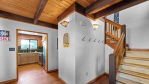 A modern interior with a wooden staircase, a kitchen with a large window, and a wall-mounted light fixture. - Lakewood Escape 3BR Retreat (South Lake Tahoe)
