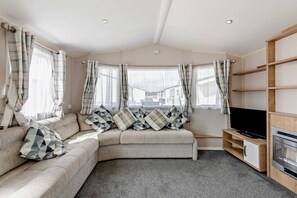 A cozy living room with a sofa set, a flat-screen TV, and a fireplace. - Host & Stay | Meadow View (Winchelsea)