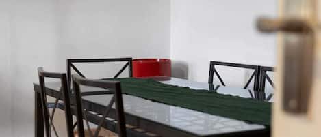A dining area with a table, chairs, and a red object on the table.