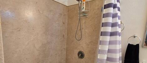 Un baño con bañera, ducha y lavamanos.