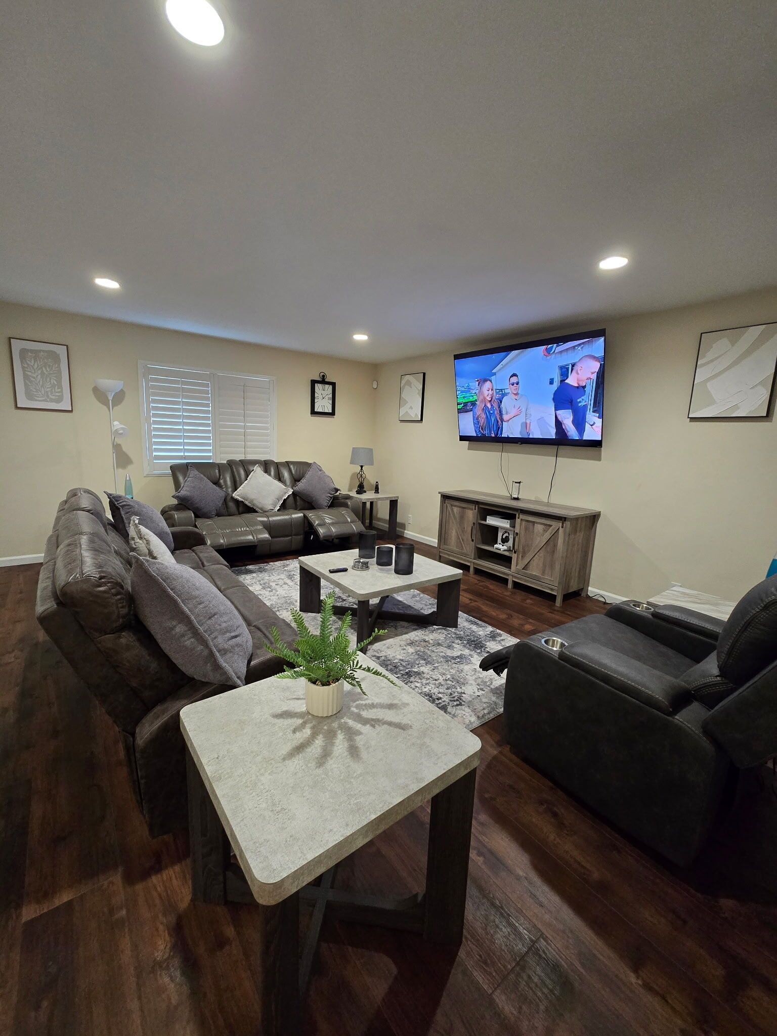 Una sala de estar moderna con un sofá modular, una mesa de centro, un televisor y un mueble de madera para entretenimiento.