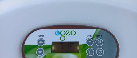 A control panel with temperature settings and jet options.
