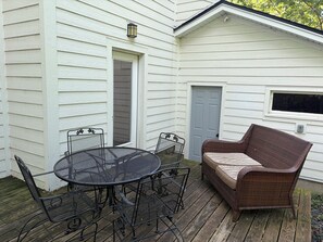 A patio with a round metal table and chairs, a wicker sofa, and a door to the house. - 3 King Beds Minnehaha Hideaway Near Downtown (Minneapolis)