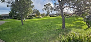 A well-maintained grassy area with trees and a pathway. - Spacious Holiday Home in Epping, 3BR, 2 baths, Sleeps 6, Free Parking. (Epping)