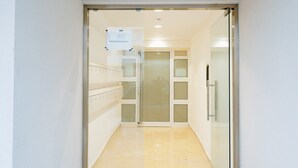 A hallway with a glass door leading to a room labeled "PALM SUITES BLOCK A".