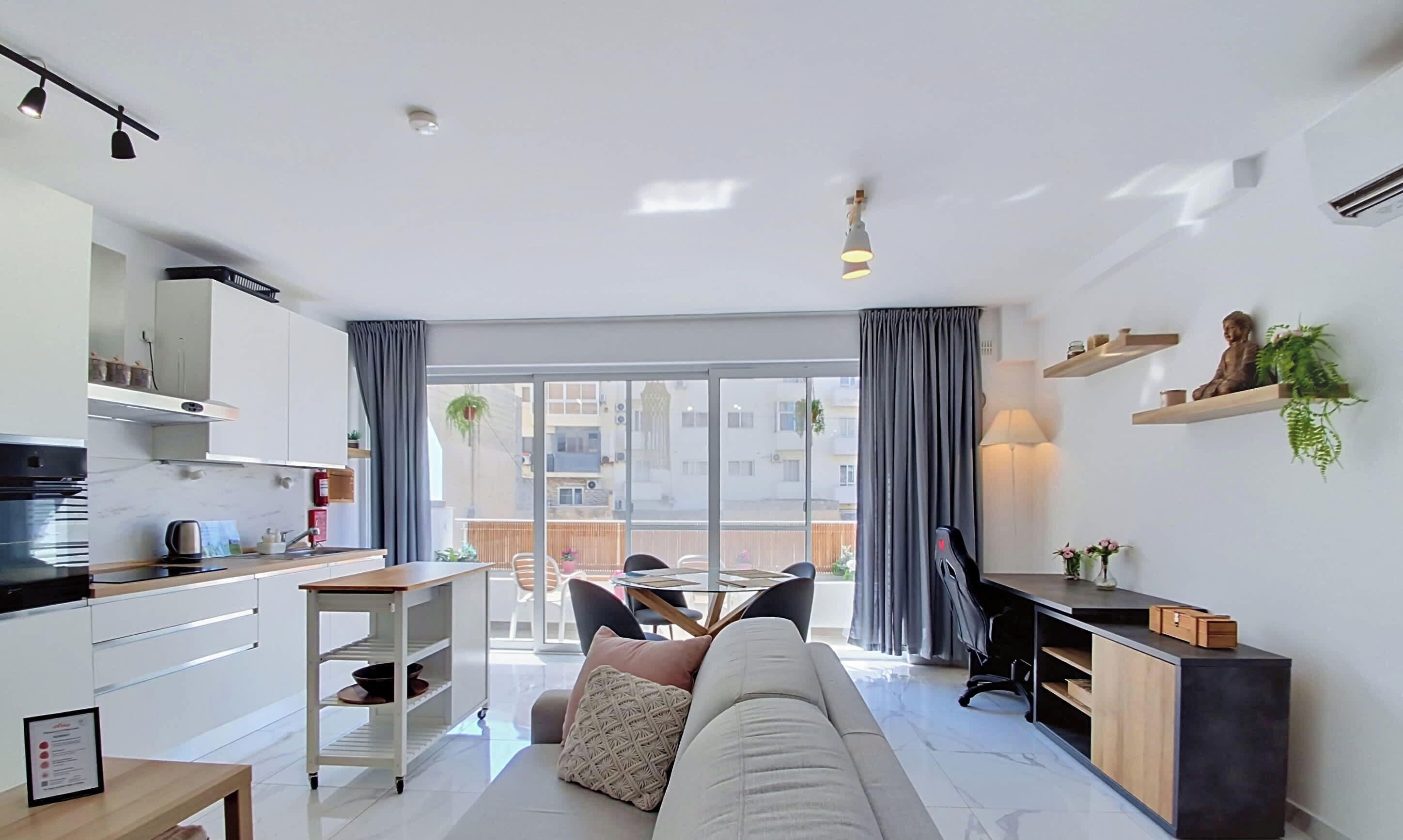 Een moderne woonkamer met een bank, een eettafel en een keukenhoek.