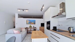 A modern kitchen with a wooden countertop, white cabinetry, and a built-in oven.