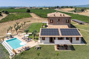 A villa with a swimming pool, solar panels, and a vineyard in the background. - Tenuta Orsini 9+3, Emma Villas (Castiglione in Teverina)