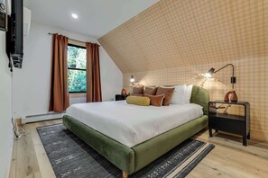 A bedroom with a large bed, a nightstand, a lamp, and a view of trees through the window. - Close to Sunday River: Hot Tub, Sauna, Cold Plunge (Bethel)