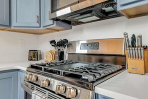 Eine moderne Küche mit Edelstahlgeräten, darunter ein Herd und ein Backofen, sowie eine eingebaute Mikrowelle über dem Herd.