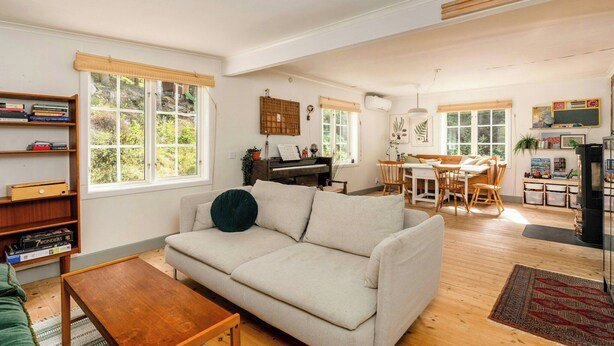 Ein geräumiges Wohnzimmer mit Sofa, Couchtisch und einem Klavier.