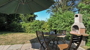An outdoor patio with a table, chairs, and a stone oven. - Yar Tor (Tavistock)