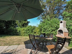 An outdoor patio with a table, chairs, and a stone oven. - Yar Tor (Tavistock)