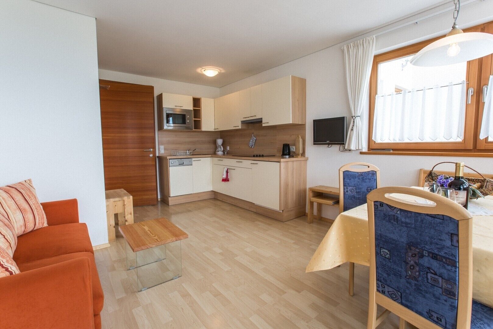 A compact living space with a kitchenette, a dining area, and a seating area.