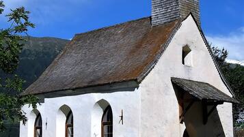 Una piccola chiesa bianca con un campanile e finestre ad arco.