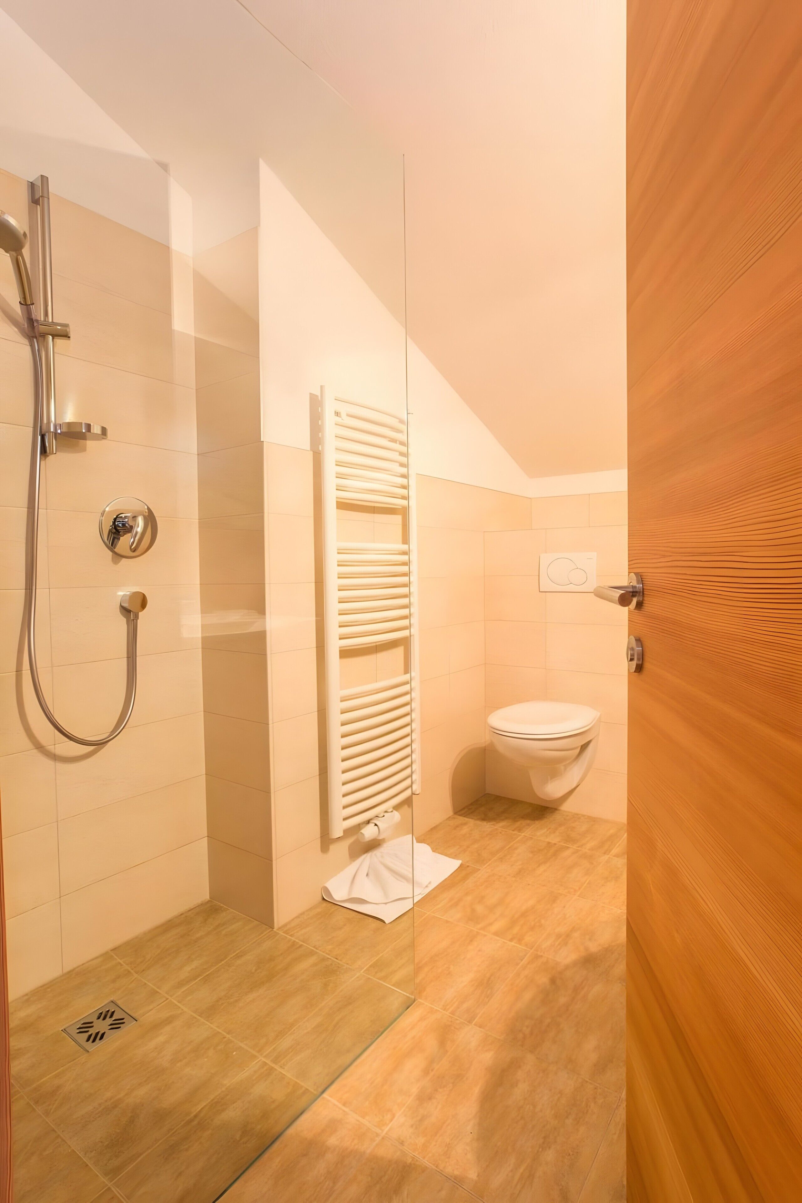 Ein modernes Badezimmer mit Dusche, Toilette und Handtuchhalter.