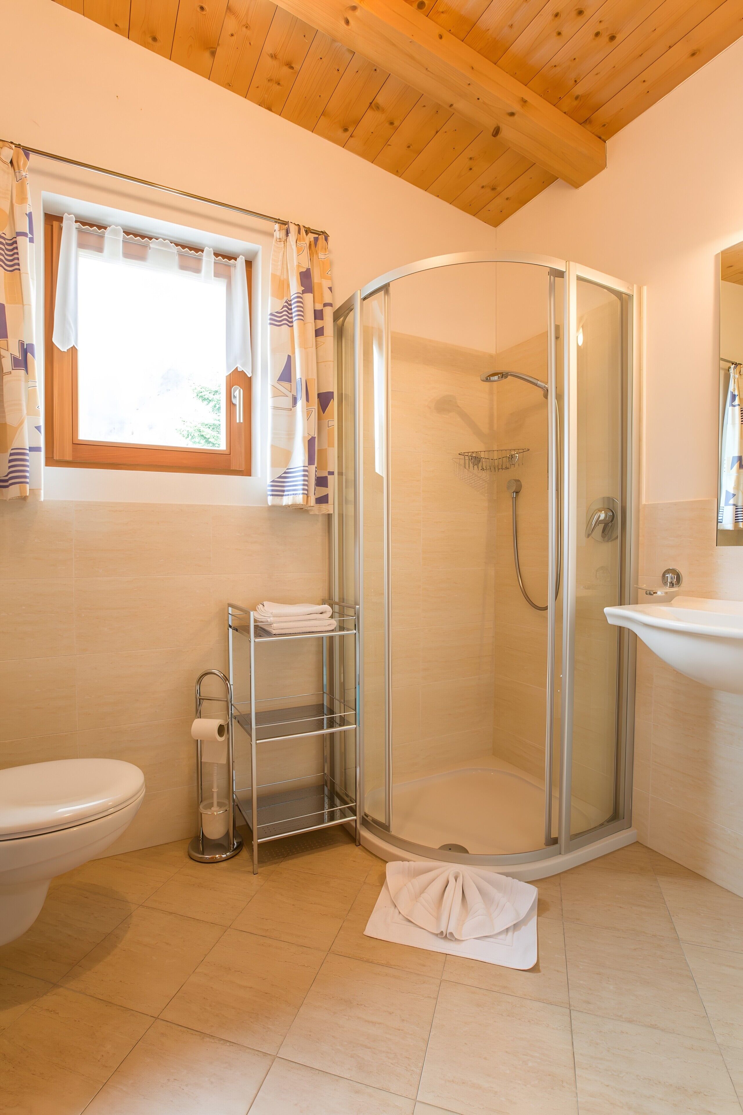 Ein modernes Badezimmer mit einer gläsernen Dusche, einer Toilette, einem Waschbecken und einem Handtuchhalter.