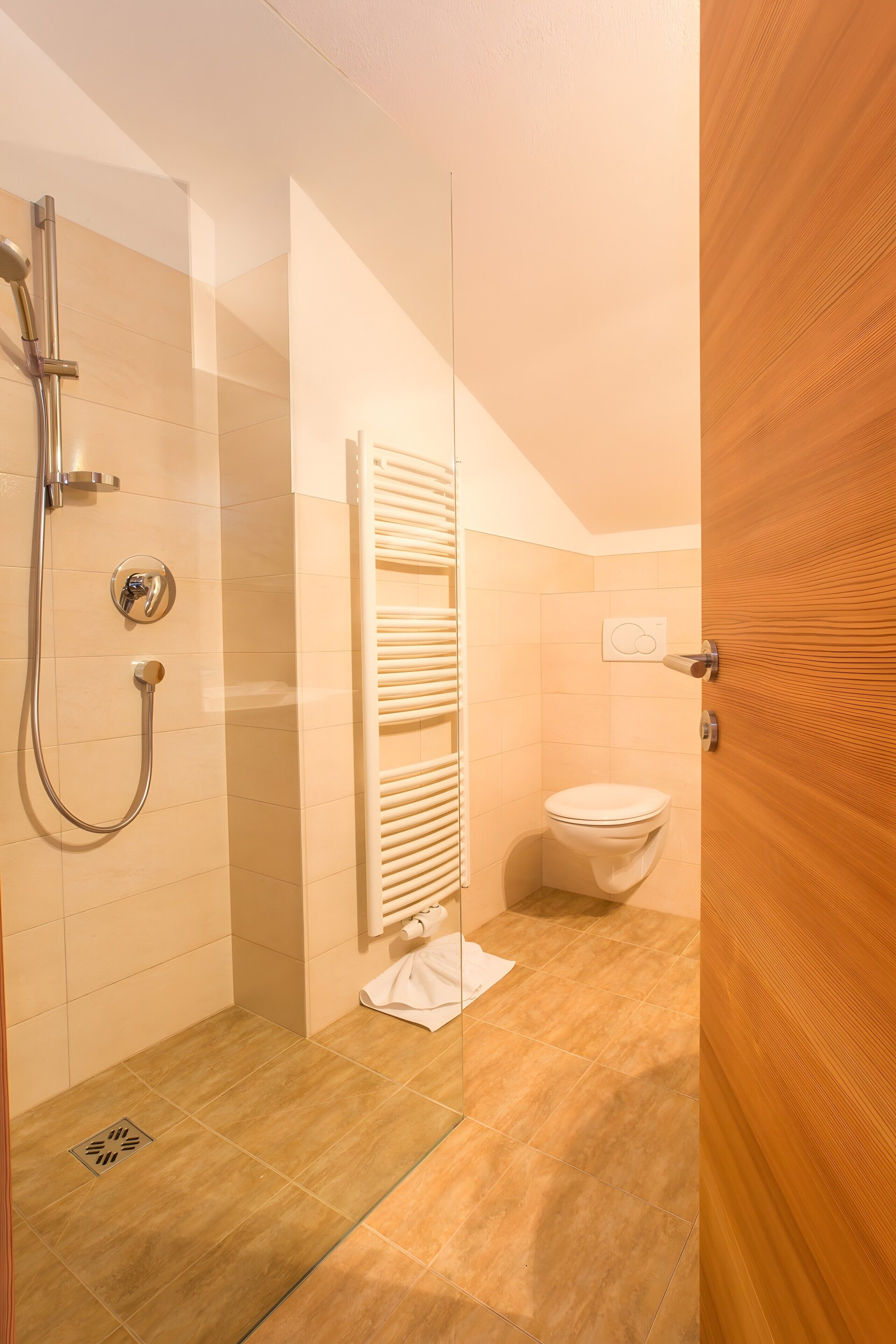 Ein modernes Badezimmer mit Dusche, Toilette und Handtuchhalter.