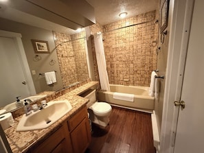 A bathroom with a sink, toilet, bathtub, and shower. - Poconos Ski-In Chalet on Telstar | Loft, Private Deck & Gas Grill (Lake Harmony)