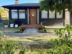 Ein Wohnhaus mit Veranda, Briefkasten und Auffahrt, die zur Garage führt.