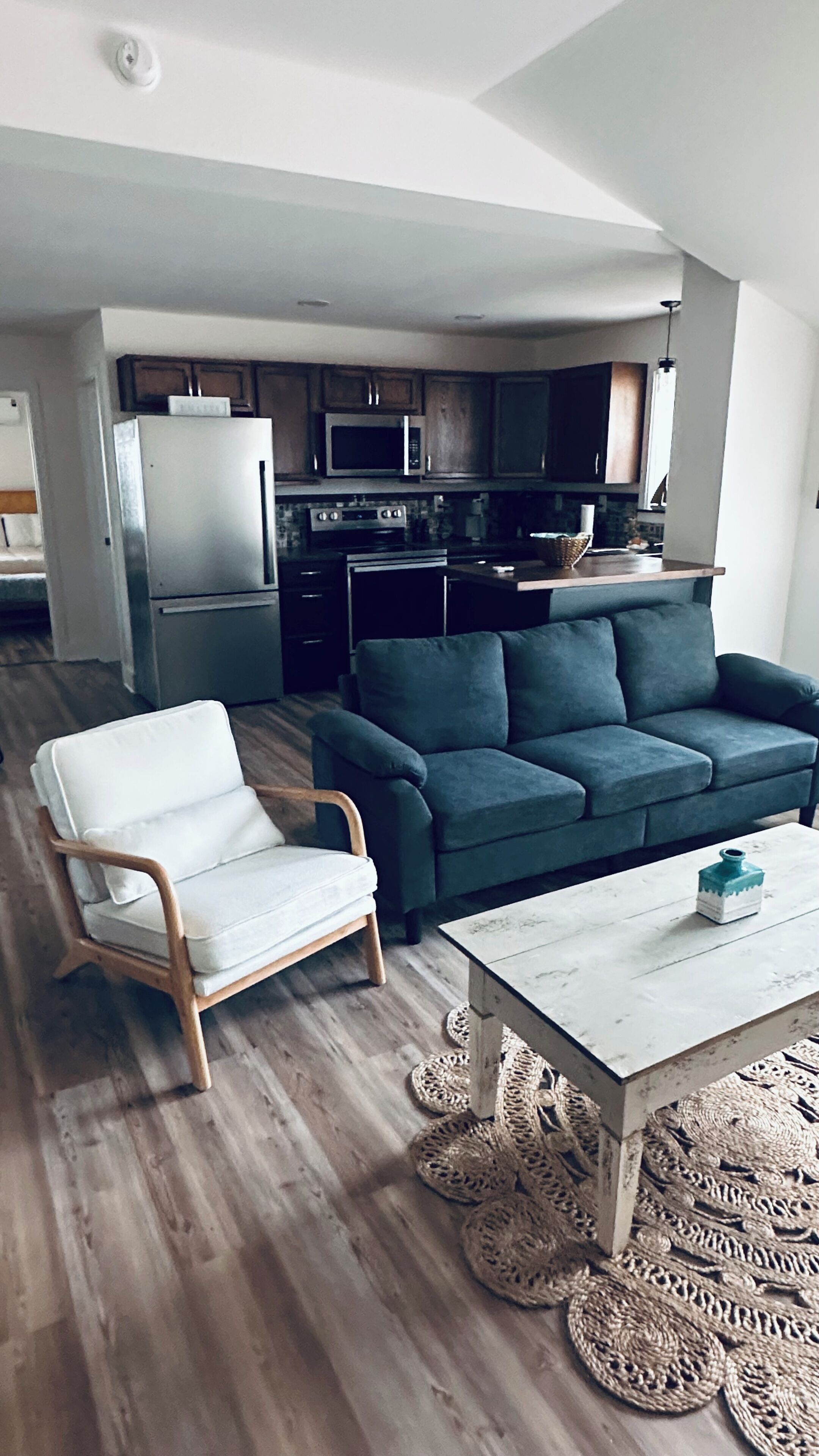Un salon moderne avec un canapé, un fauteuil et une table basse.