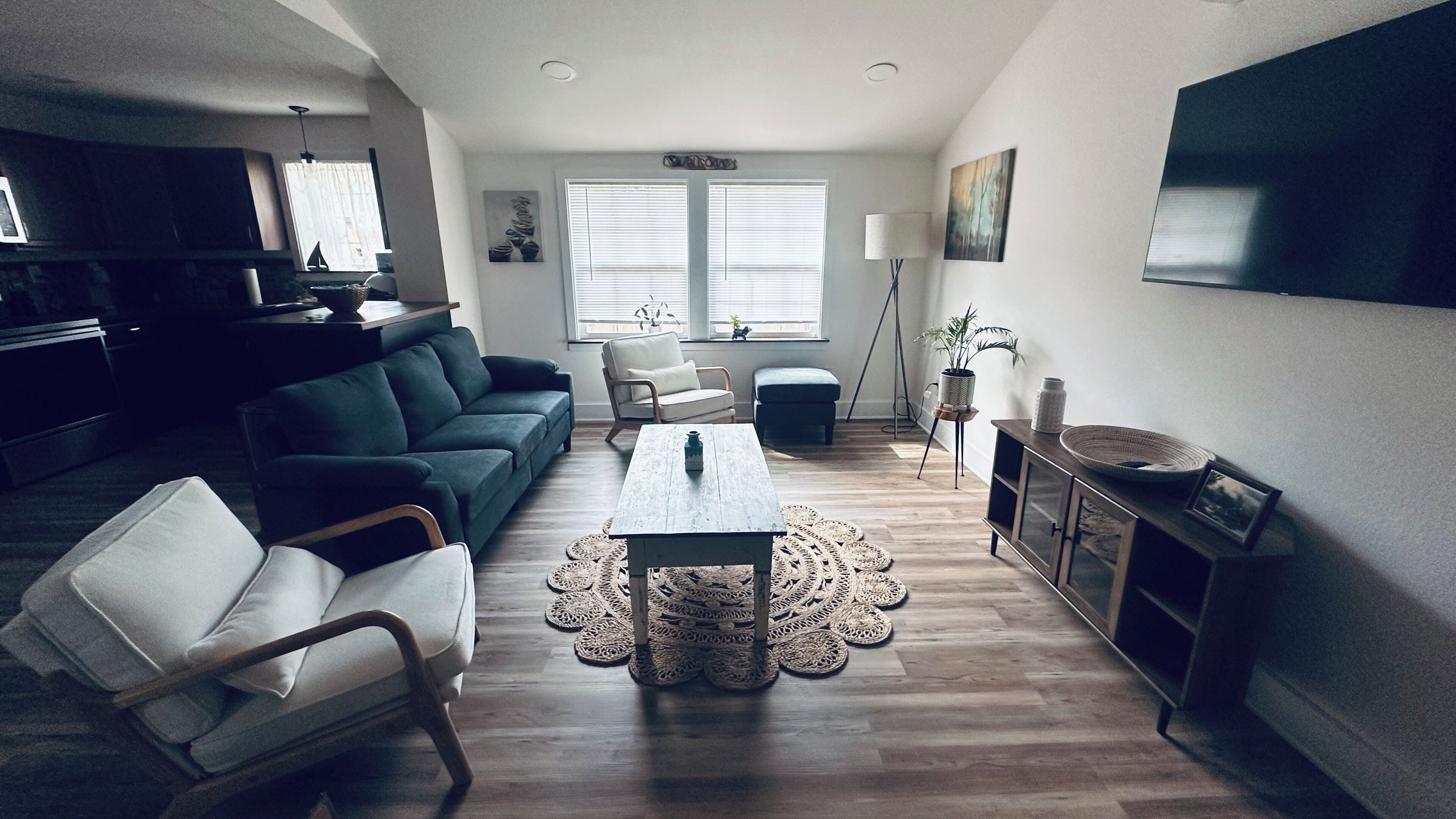 A living room with a sofa, a coffee table, a TV, and a dining area with a table and chairs.