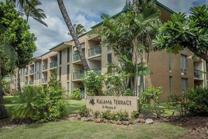 A multi-story hotel with balconies, palm trees, and a sign reading 'Kalama Terrace 33 Wakala St.' - Kalama Terrace L203 South Kihei Retreat with Pool, Lanai, Ocean Nearby (Kihei)