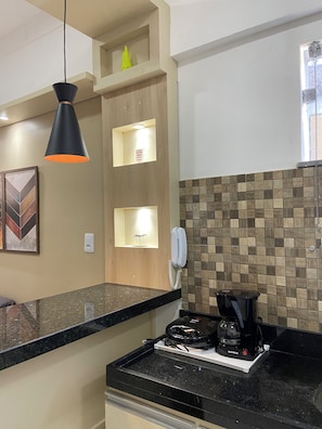 A kitchen with a black countertop, a coffee maker, and a telephone. - 207 Apto 2 Qtos Lindo (Belém)