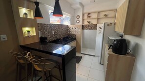 A compact kitchen with a central island, bar stools, a refrigerator, and a microwave. - 207 Apto 2 Qtos Lindo (Belém)