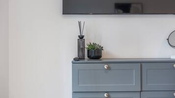 A grey dresser with a flat-screen TV mounted above it.