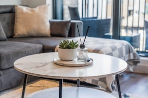 A round table with a potted plant and a diffuser in the center. - Luxury 2-Bedroom Apartment Near Slough Station | Sleeps 8 | Balcony (Slough)