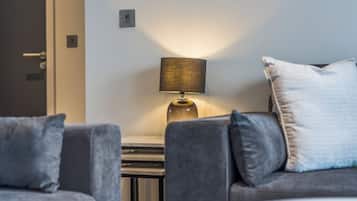 A modern living room with a sofa, a lamp, and a small table.