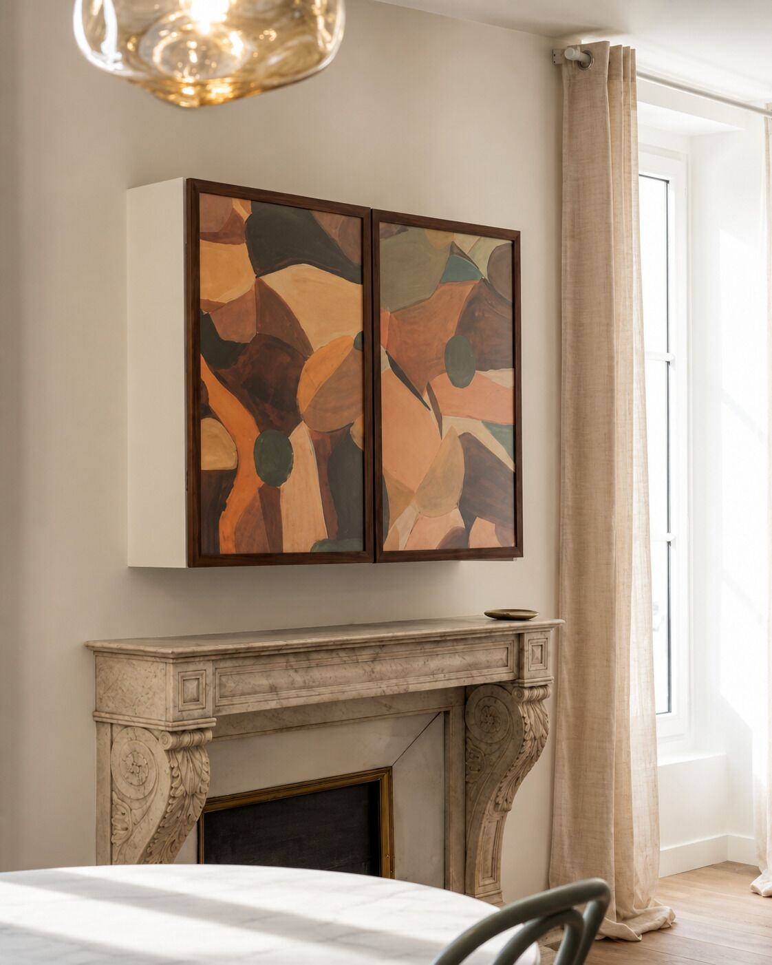 Una habitación con chimenea, una mesa de comedor y arte abstracto en la pared.