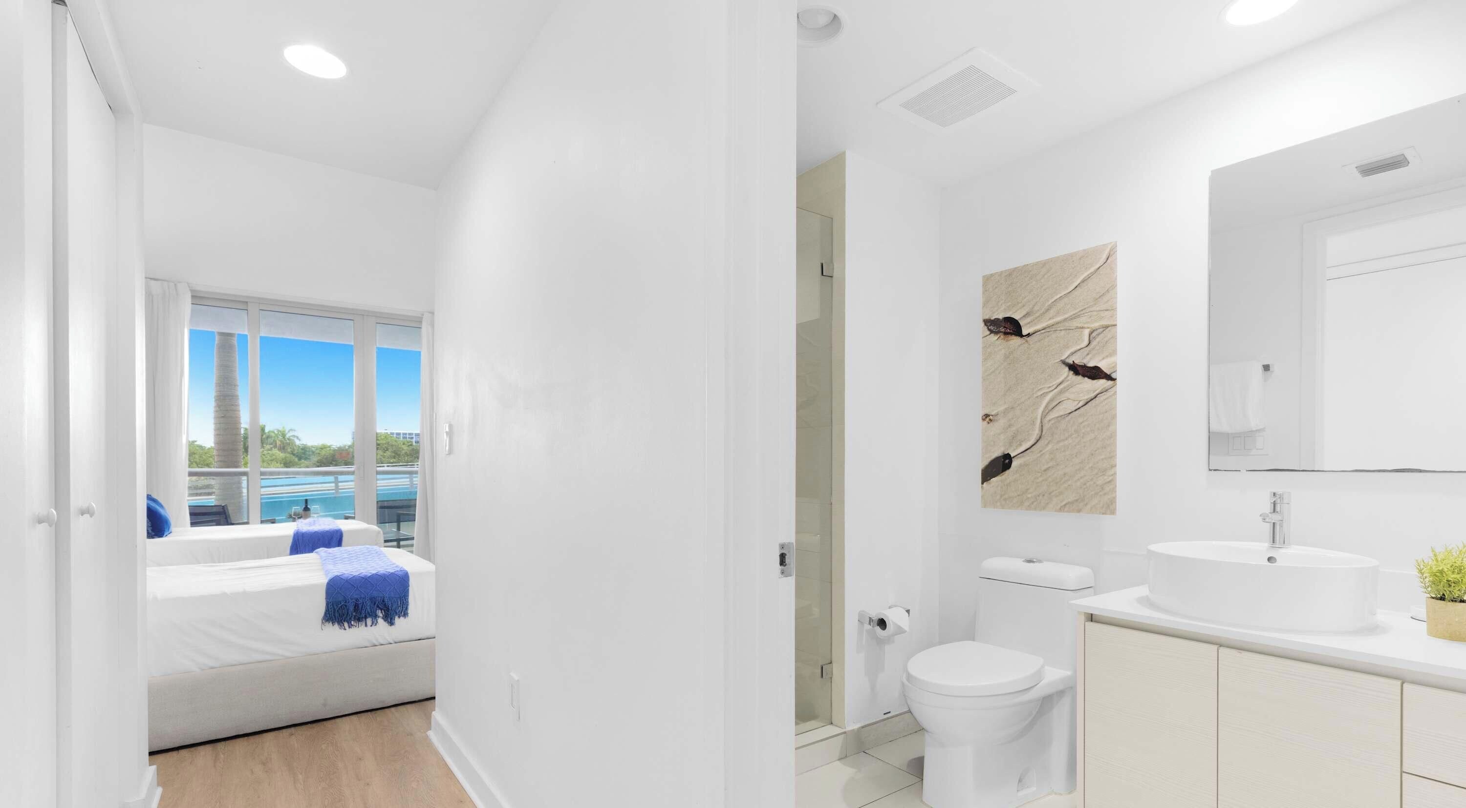 Un baño moderno con un espejo grande, un lavabo y un inodoro.