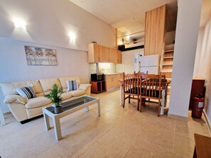 Ein Wohnzimmer mit einer Couch, einem Couchtisch und einem Essbereich mit Stühlen und einem Tisch.