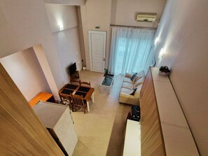 A compact living space with a dining area, a sofa, and a kitchenette. - Penelope's Messini Suite - Central, full amenities, 300 Mbps (Messini)