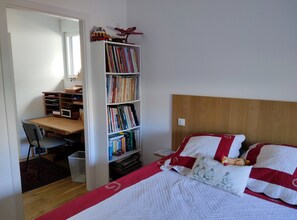 A bedroom with a bed, a bookshelf, a desk, and a chair. - Suite (bedroom, bathroom) in a house, residential neighborhood, additional amenities (Schiltigheim)