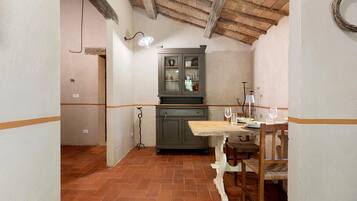 Una cucina rustica con un tavolo di legno, un armadietto e una lampada a sospensione.